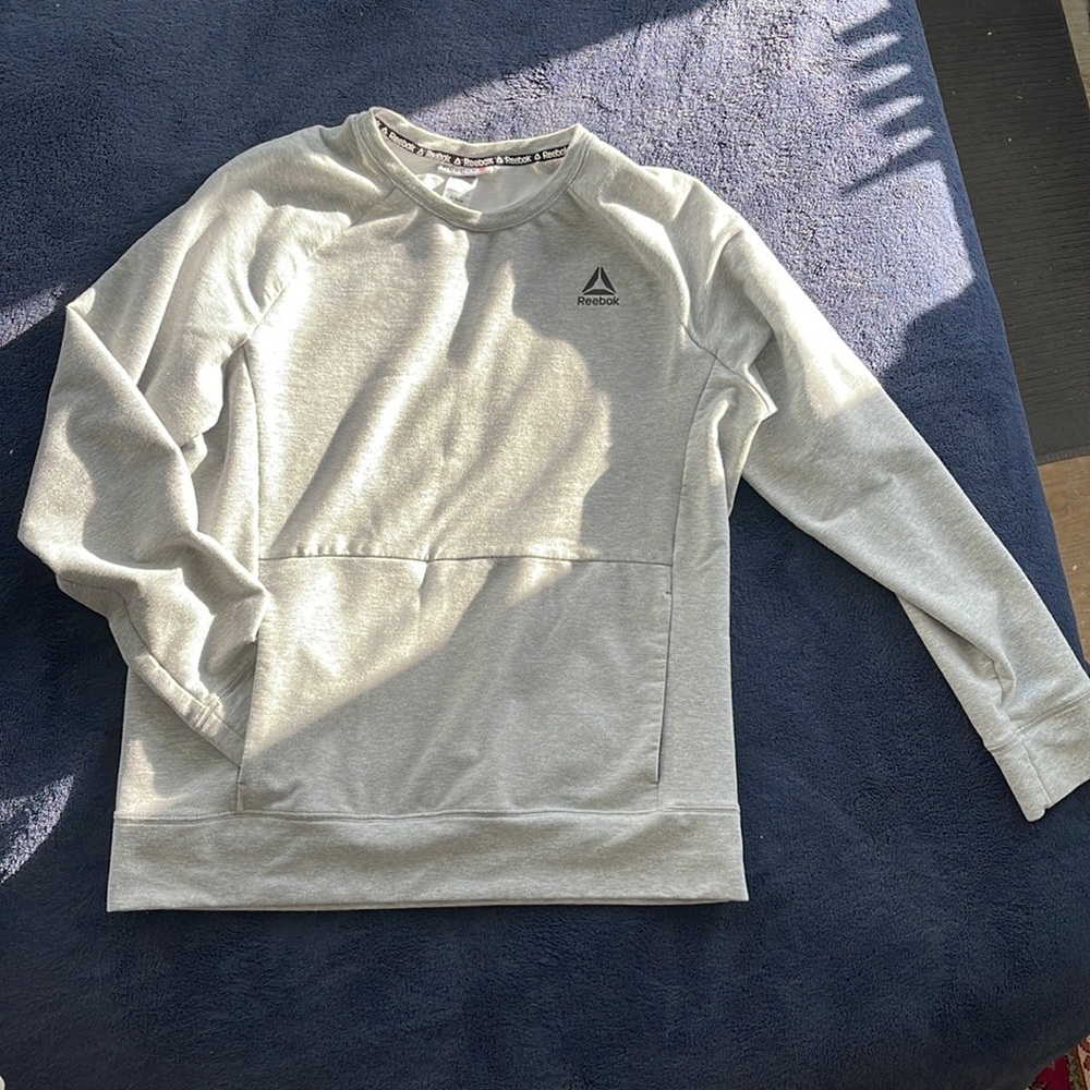 Reebok hoodie with slim front pocket.